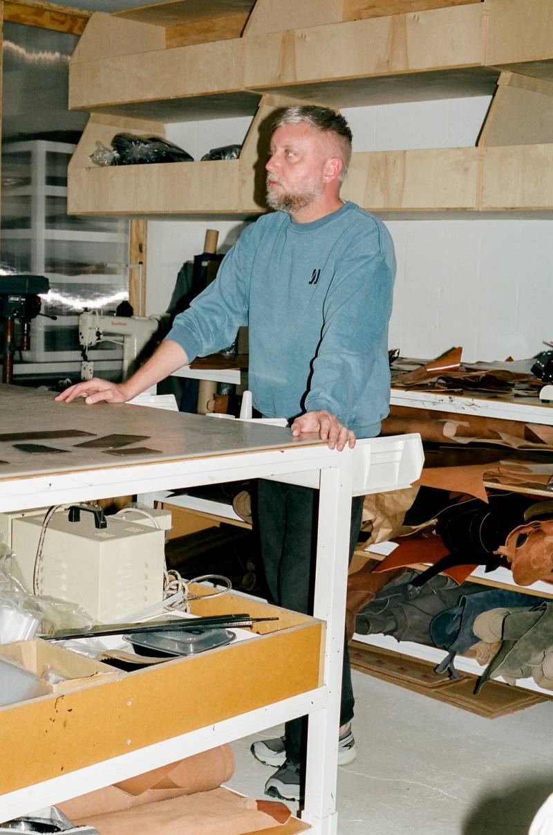 COMUNE artist Jason Gregory from MAKR standing in a workshop with tools and materials around
