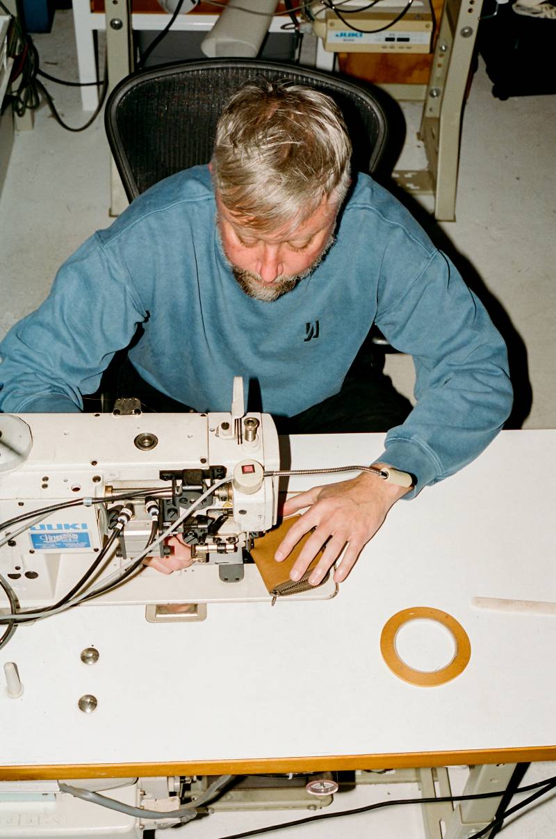 COMUNE artist Jason Gregory from MAKR working on a sewing machine in a workshop setting