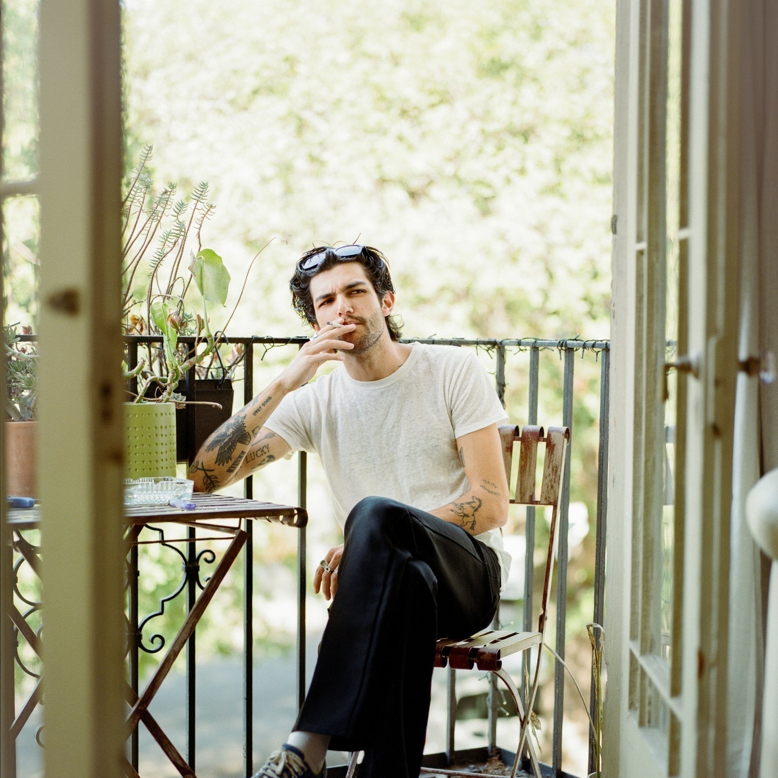 Comune artist Brandon sitting outside his balcony