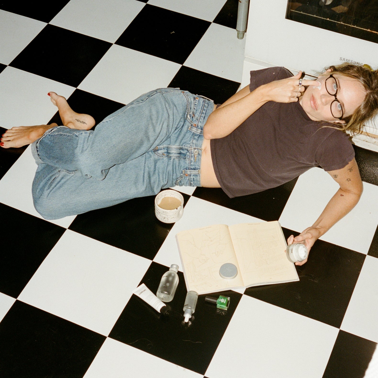 Women lying on the floor using COMUNE Essentials Skincare products