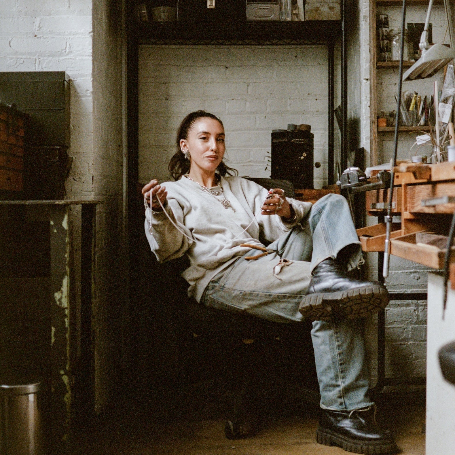 Comune project artist Lizz Jardim sitting at her workshop