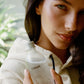 Person holding a bottle labeled 'COMUNE' with a blurred natural background