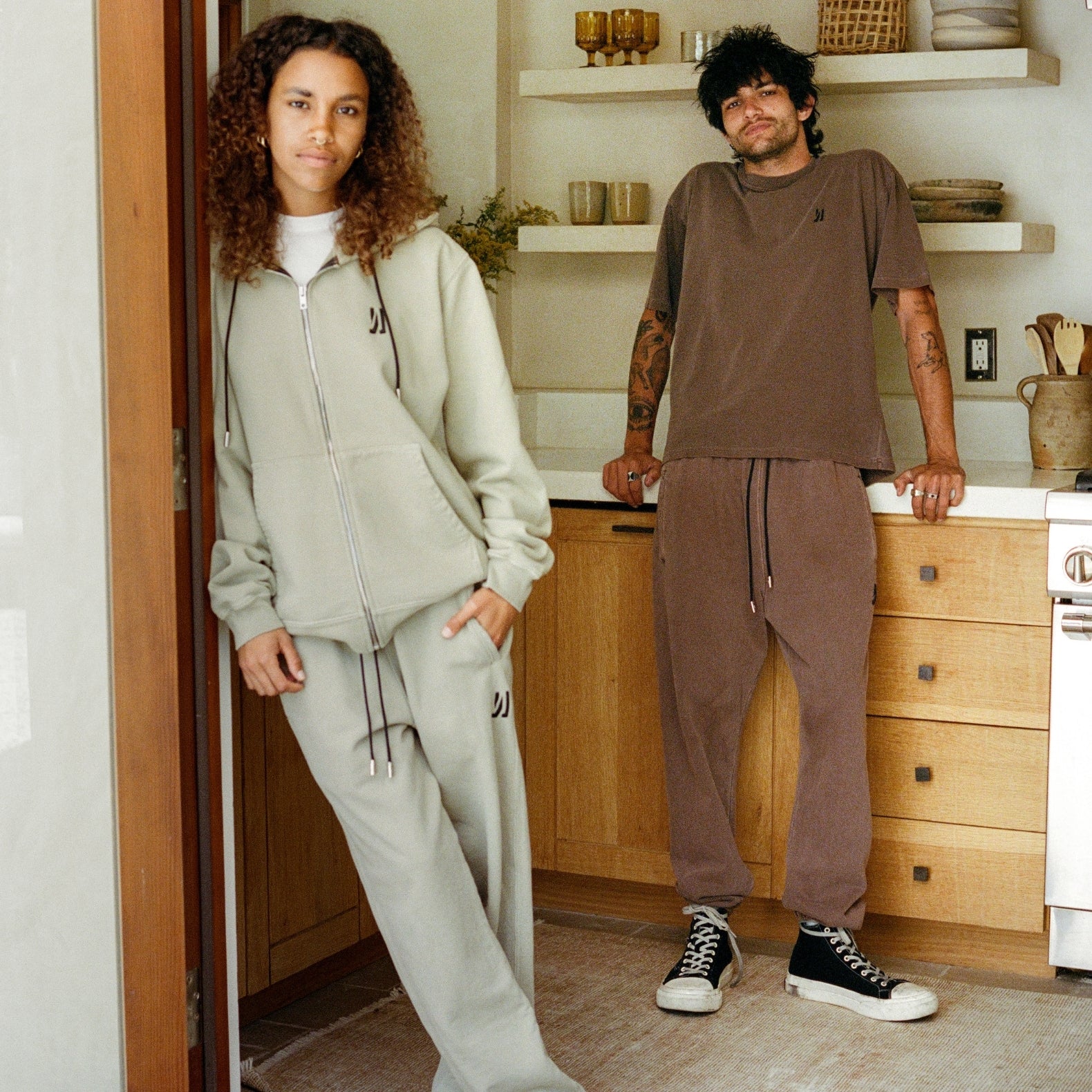 Twe person standing infront of an outdoor kitchen wearing COMUNE clothing. COMUNE Ryder Oversized Tee | Brown