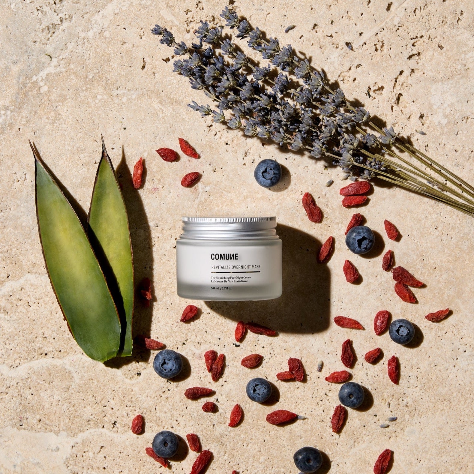 COMUNE Revitalize Overnight Mask 50mL/1.7 fl.oz, showcasing actual ingredients on natural stone color background.  A dual function overnight mask and night cream with superfood ingredients.  Acai, goji, blue agave, niacinamide, hyaluronic acid, and squalane. Clean, natural, vegan & cruelty-free. Made in Korea.