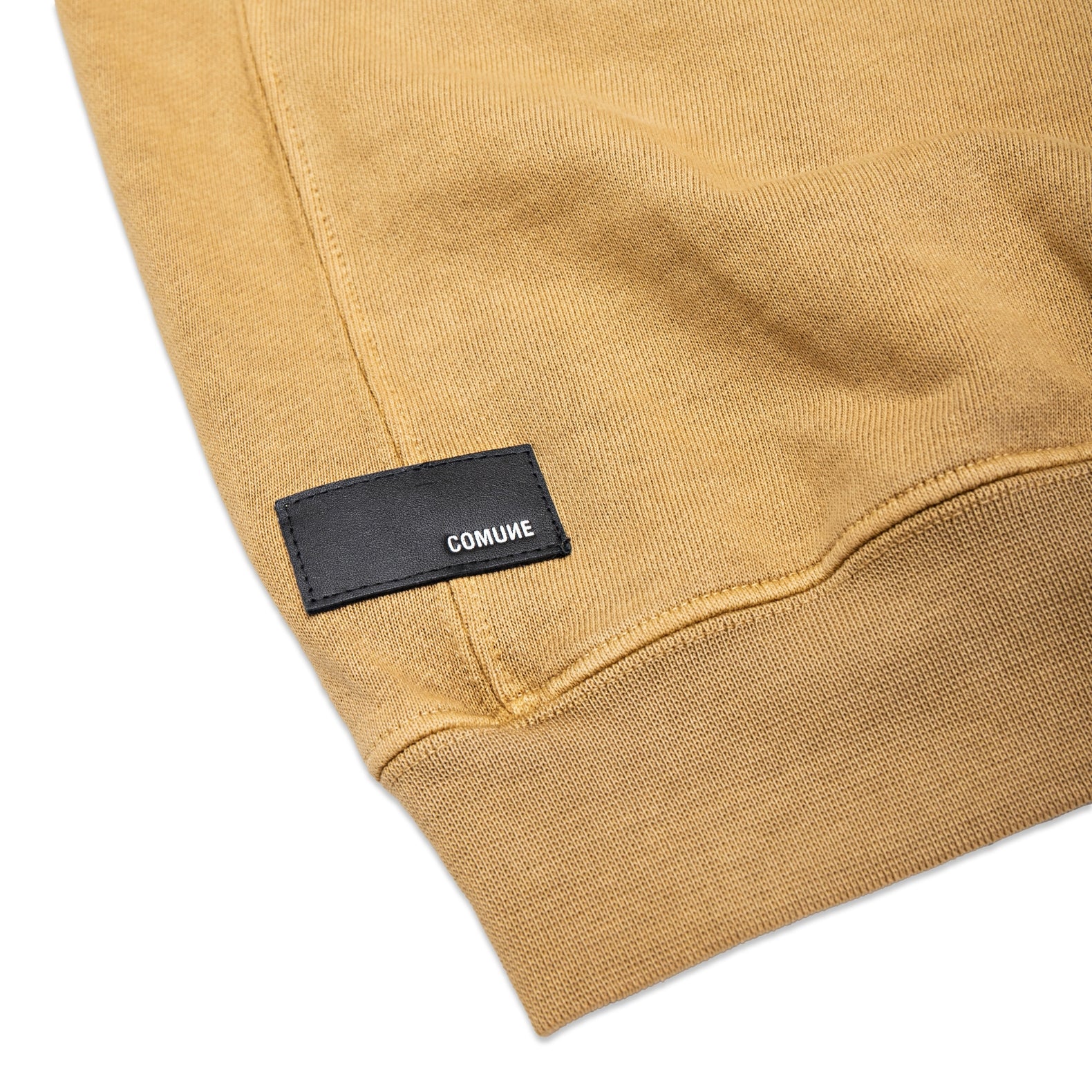 Comune Duke Crew heavyweight cotton in acorn color on white background, leather patch close up. COMUNE DUKE CREW | Acorn