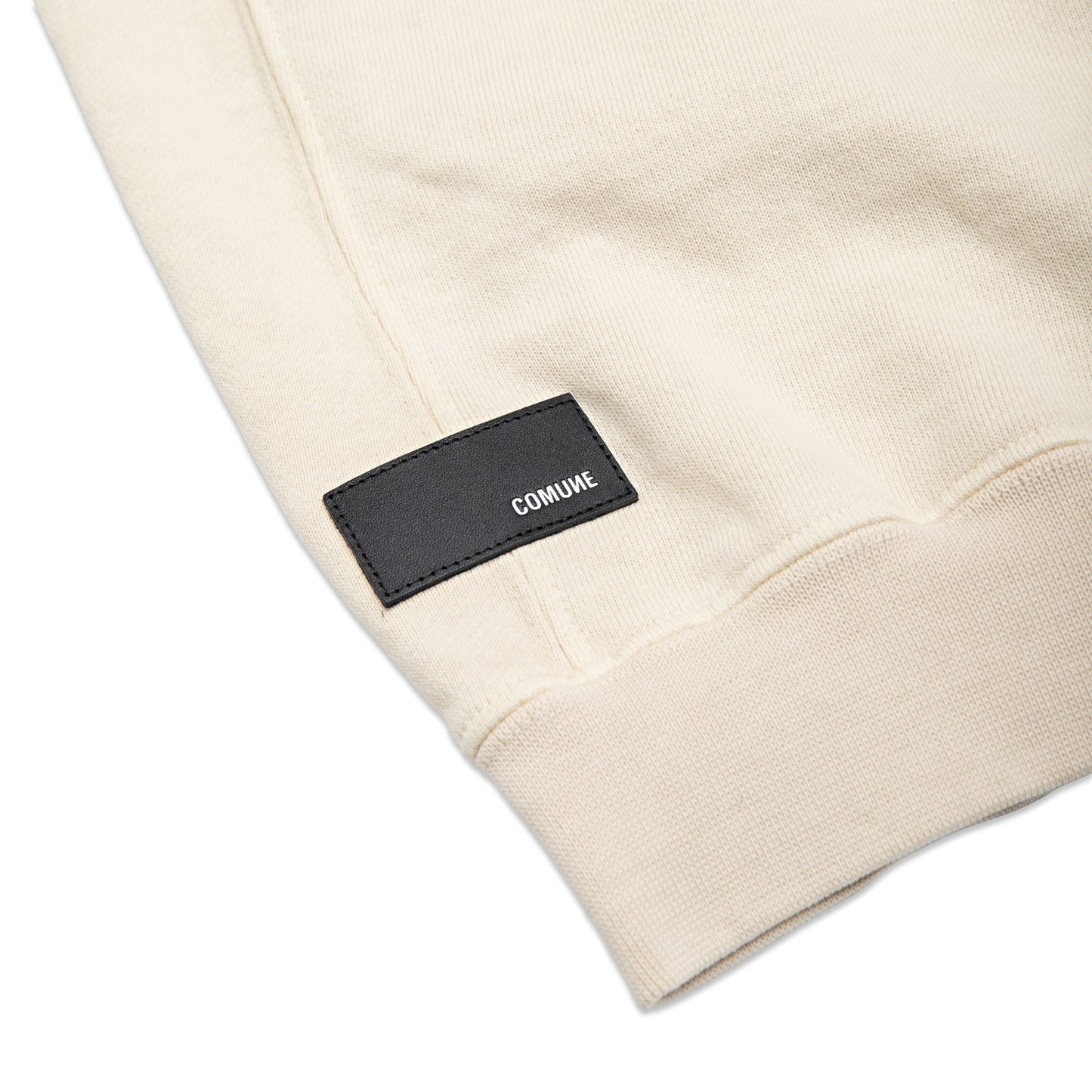 Comune Duke Crew heavyweight cotton in bone color on white background, leather patch close up. COMUNE DUKE CREW | Bone