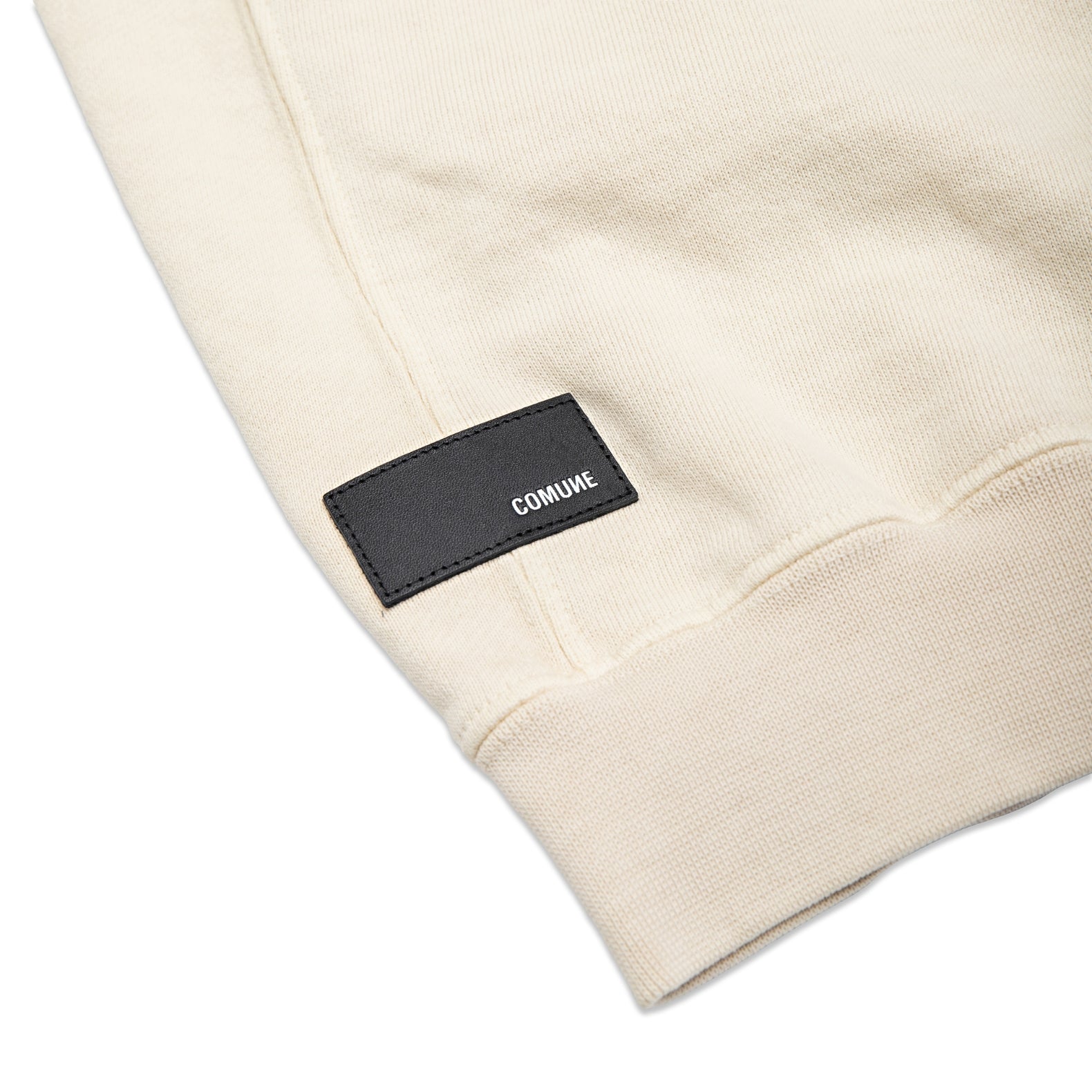 Comune Duke Crew heavyweight cotton in bone color on white background, leather patch close up. COMUNE DUKE CREW | Bone