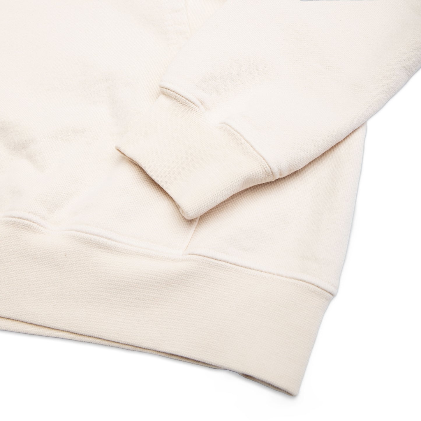 Comune Duke Hoodie heavyweight cotton in bone color on white background, hem close up. COMUNE DUKE HOODIE | Bone