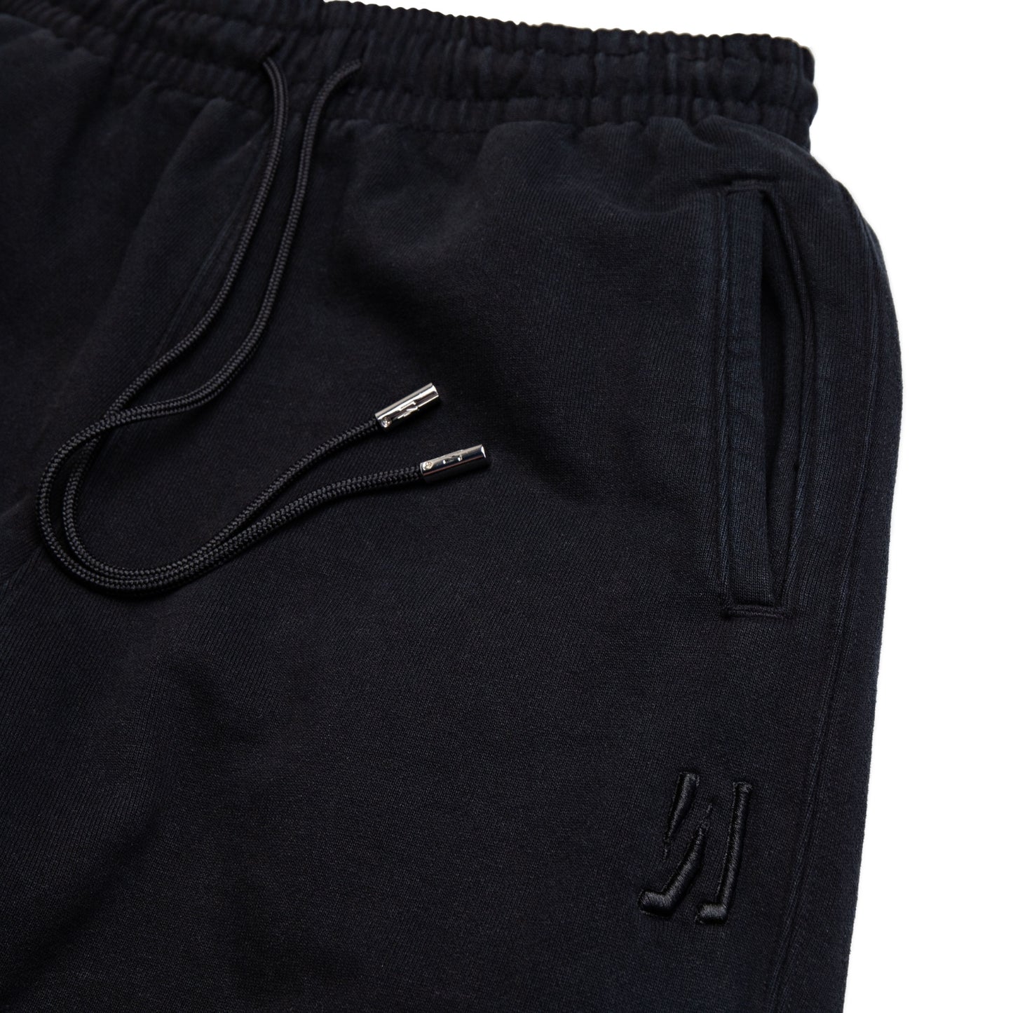 Comune Duke Sweatpants in heavyweight cotton with side gusset in black color on white background, logo close up. COMUNE DUKE SWEATPANTS | Black
