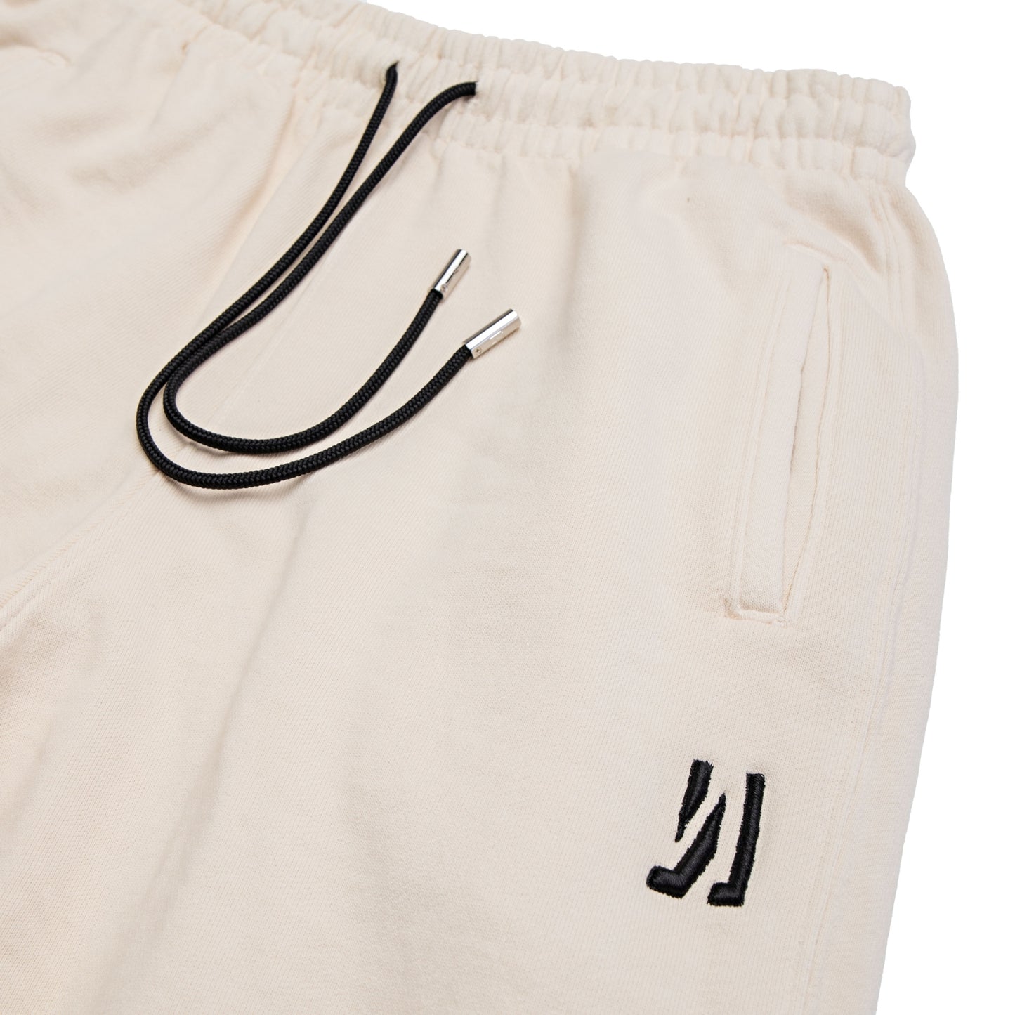 Comune Duke Sweatpants in heavyweight cotton with side gusset in bone color on white background, logo close up. COMUNE DUKE SWEATPANTS | Bone 