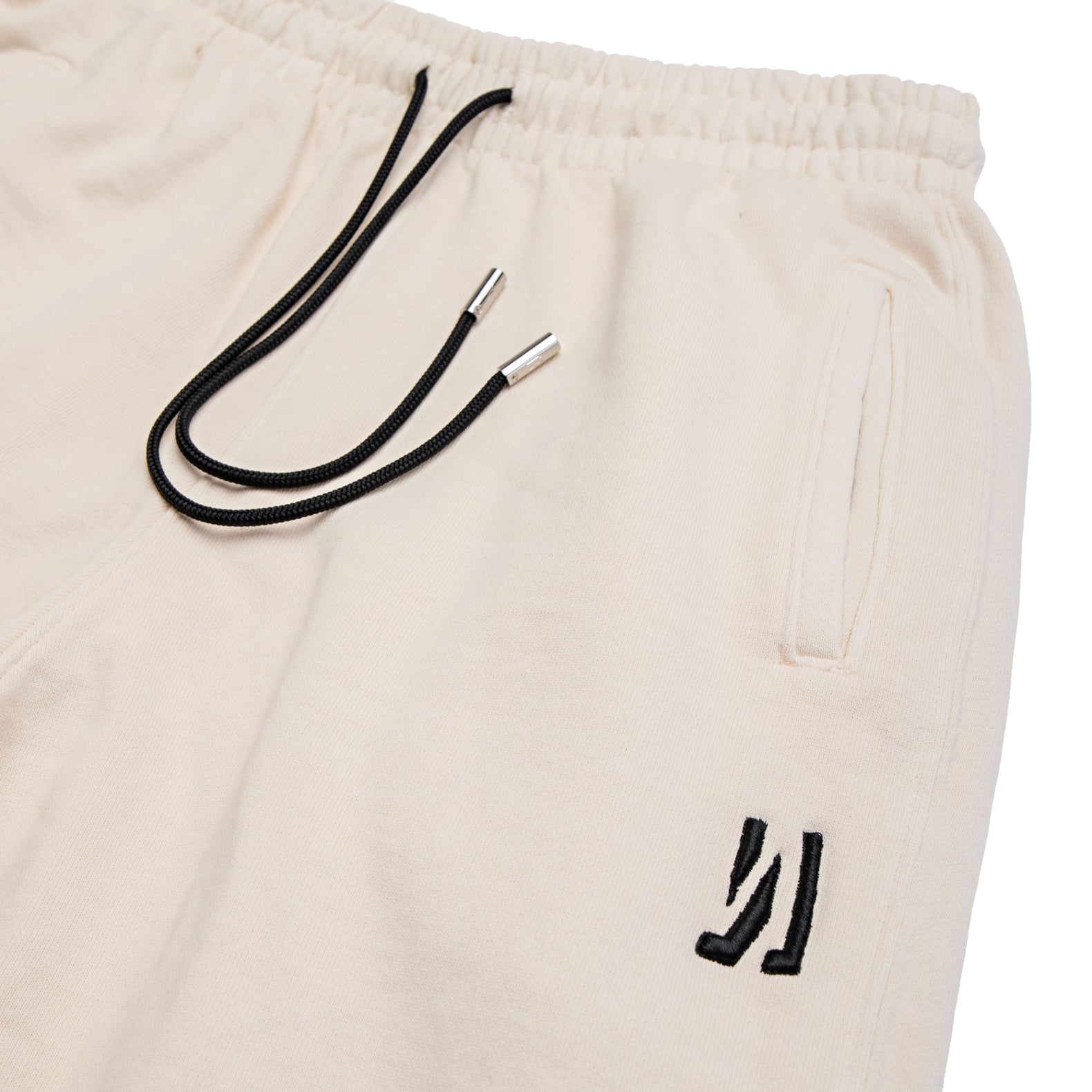 Comune Duke Sweatpants in heavyweight cotton with side gusset in bone color on white background, logo close up. COMUNE DUKE SWEATPANTS | Bone 