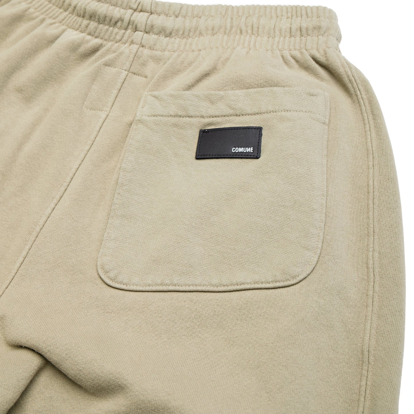 Comune Duke Sweatpants in heavyweight cotton with side gusset in sage color on white background, leather patch close up. COMUNE DUKE SWEATPANTS | Sage
