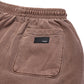 Comune Enzo Joggers heavyweight cotton in brown color on white background, leather patch close up. COMUNE ENZO JOGGER | Brown