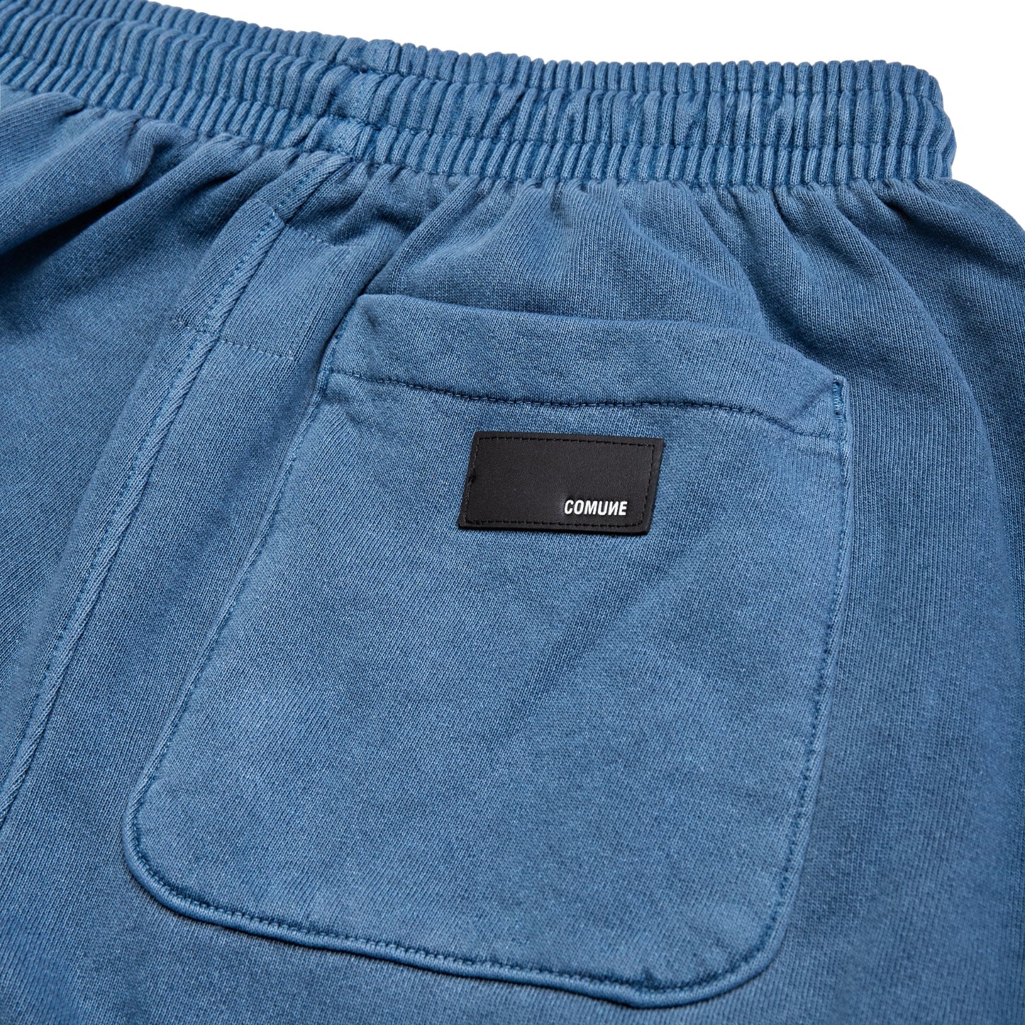 Comune Enzo Joggers heavyweight cotton in marine color on white background, leather patch close up. COMUNE ENZO JOGGER | Marine