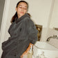 COMUNE model  in a bathroom with comune essentials cleanser bottle on the counter