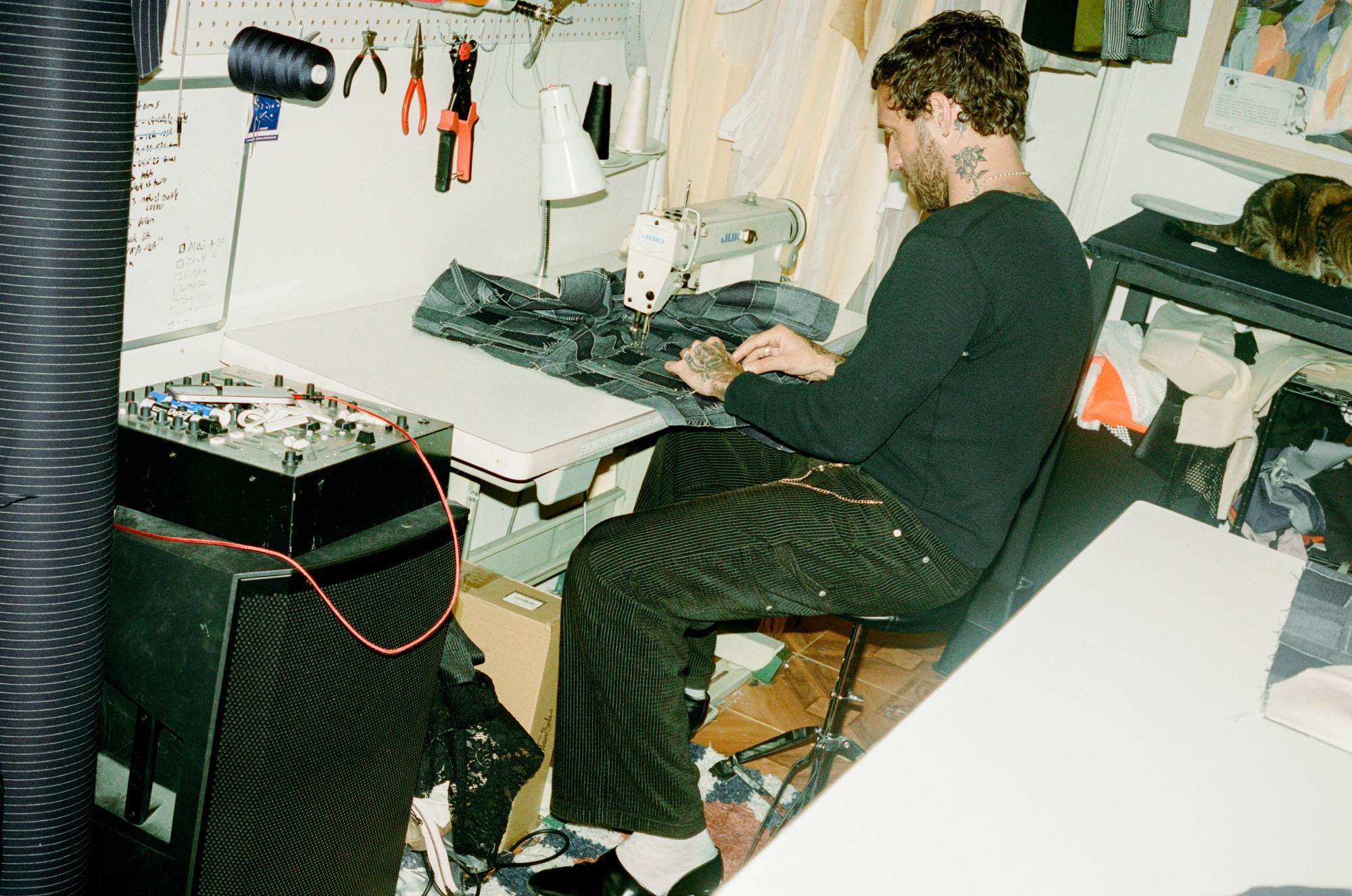 COMUNE artist Jackson Owens working at a sewing machine in a workshop setting