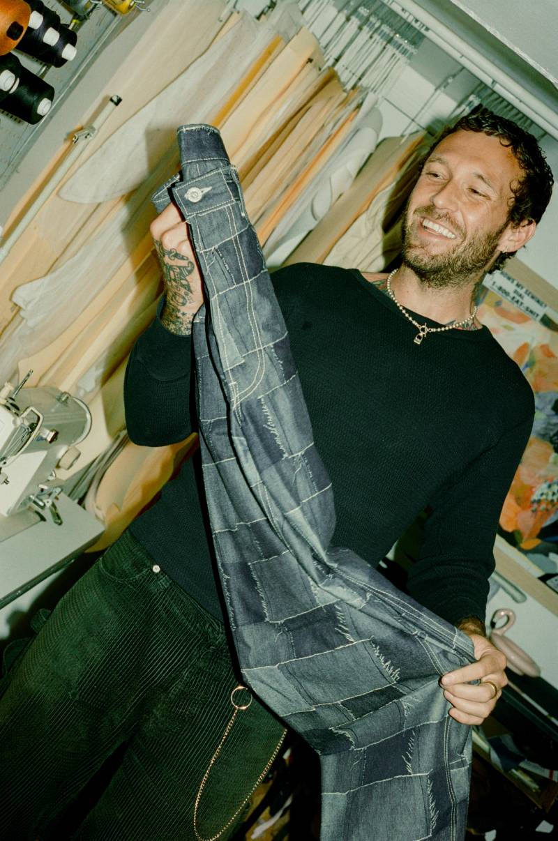Man holding a pair of jeans in a workshop setting
