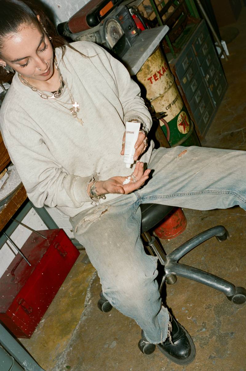 Person sitting on a chair holding a small object in a workshop setting