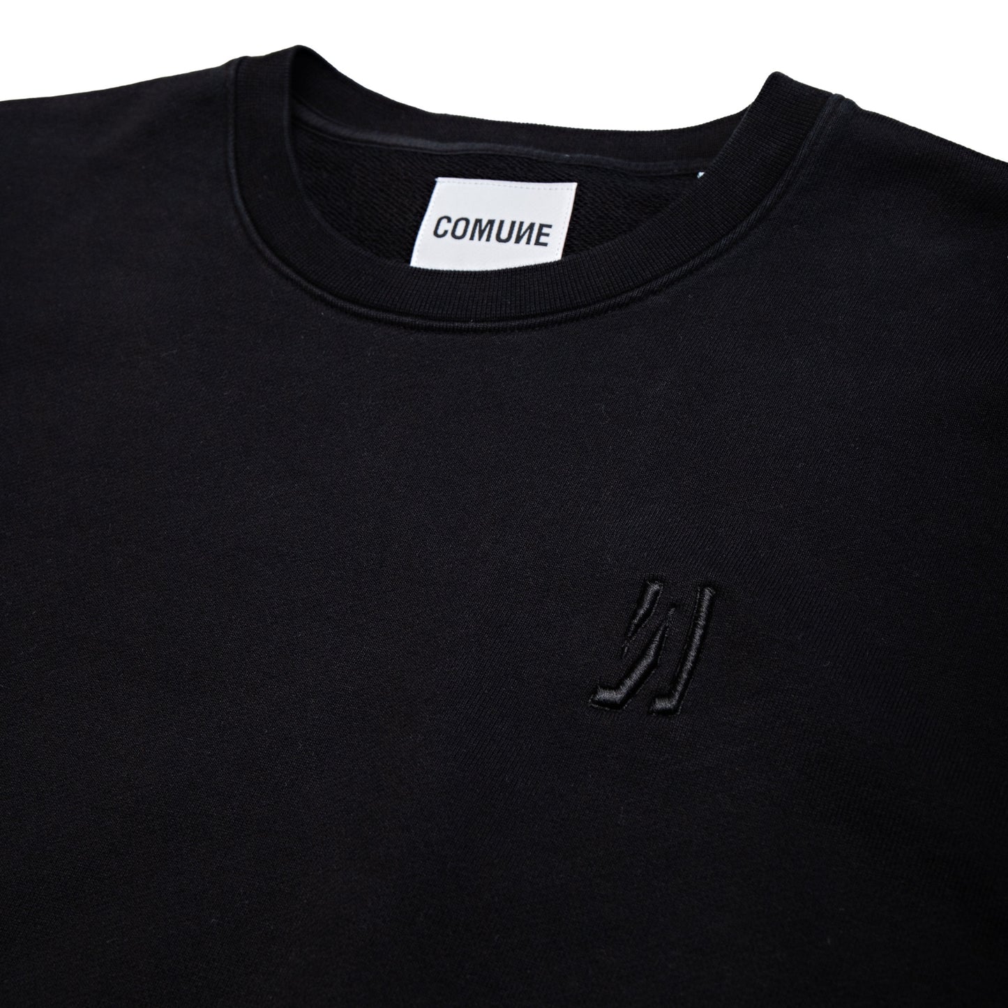 Comune Luka Crewneck heavyweight cotton sweatshirt in black color on white background, close up of the logo. COMUNE LUKA CREW | Black
