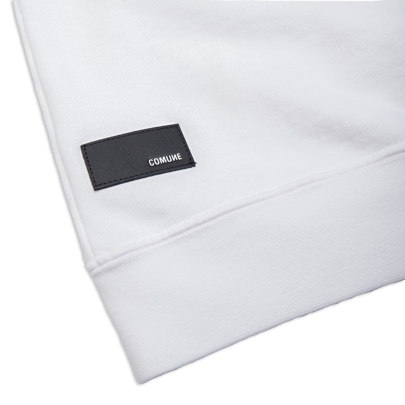 Comune Luka crewneck heavyweight cotton sweatshirt in white color on white background, leather patch close up. COMUNE LUKA CREW | White