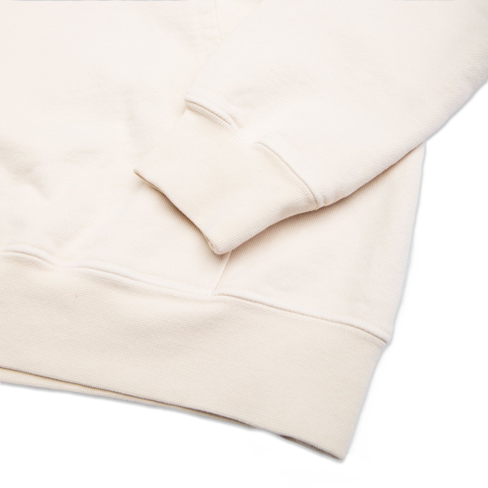 Comune Luka Hoodie heavyweight cotton sweatshirt in bone color on white background, hem close up. COMUNE LUKA HOODIE | Bone