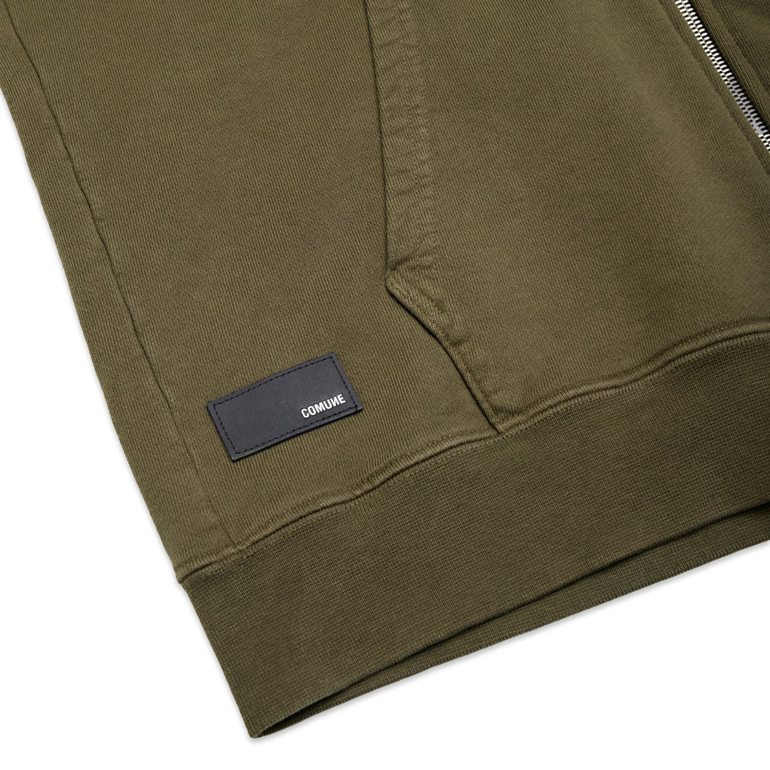 Comune Luka Zip-up heavyweight cotton hoodie in army green color on a white background, leather patch close up. COMUNE LUKA ZIP-UP | Army Green