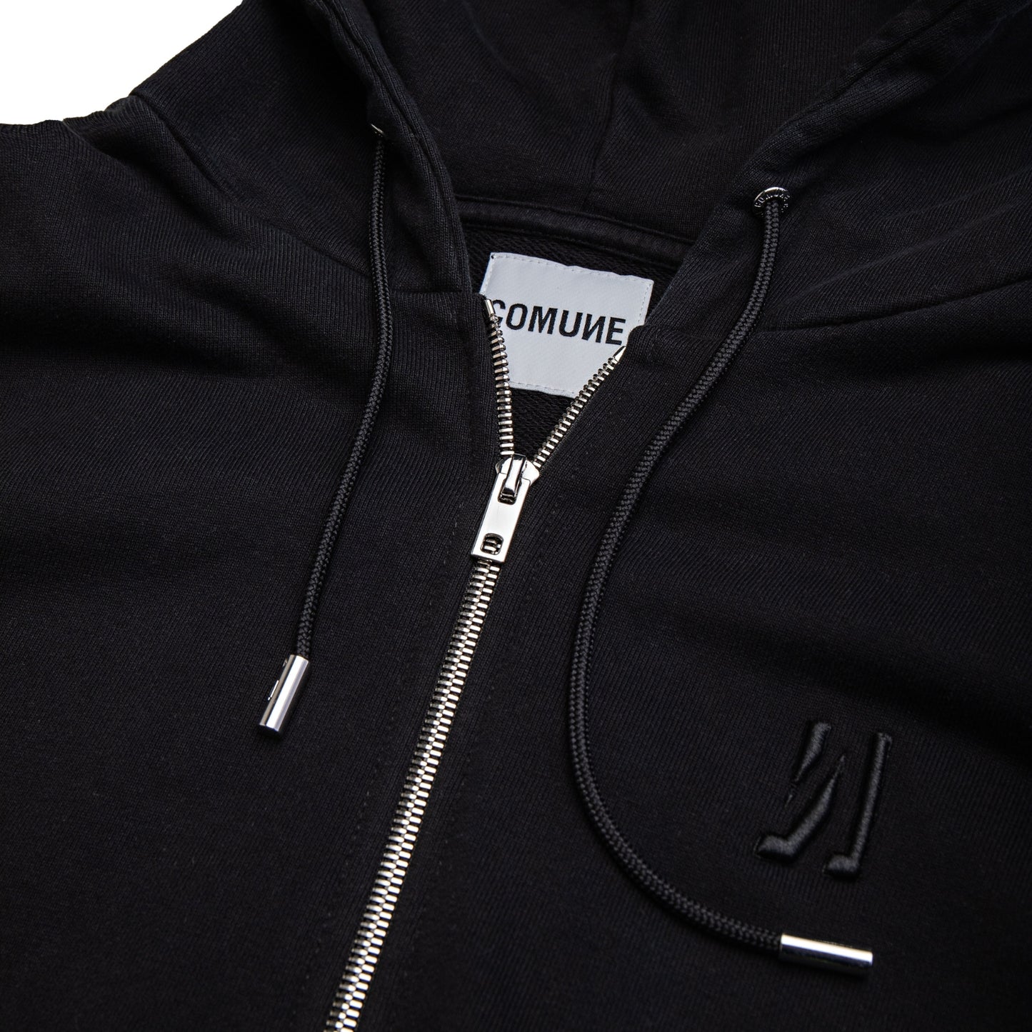 Comune Luka Zip-up heavyweight cotton hoodie in black color on a white background, logo close up. COMUNE LUKA ZIP-UP | Black