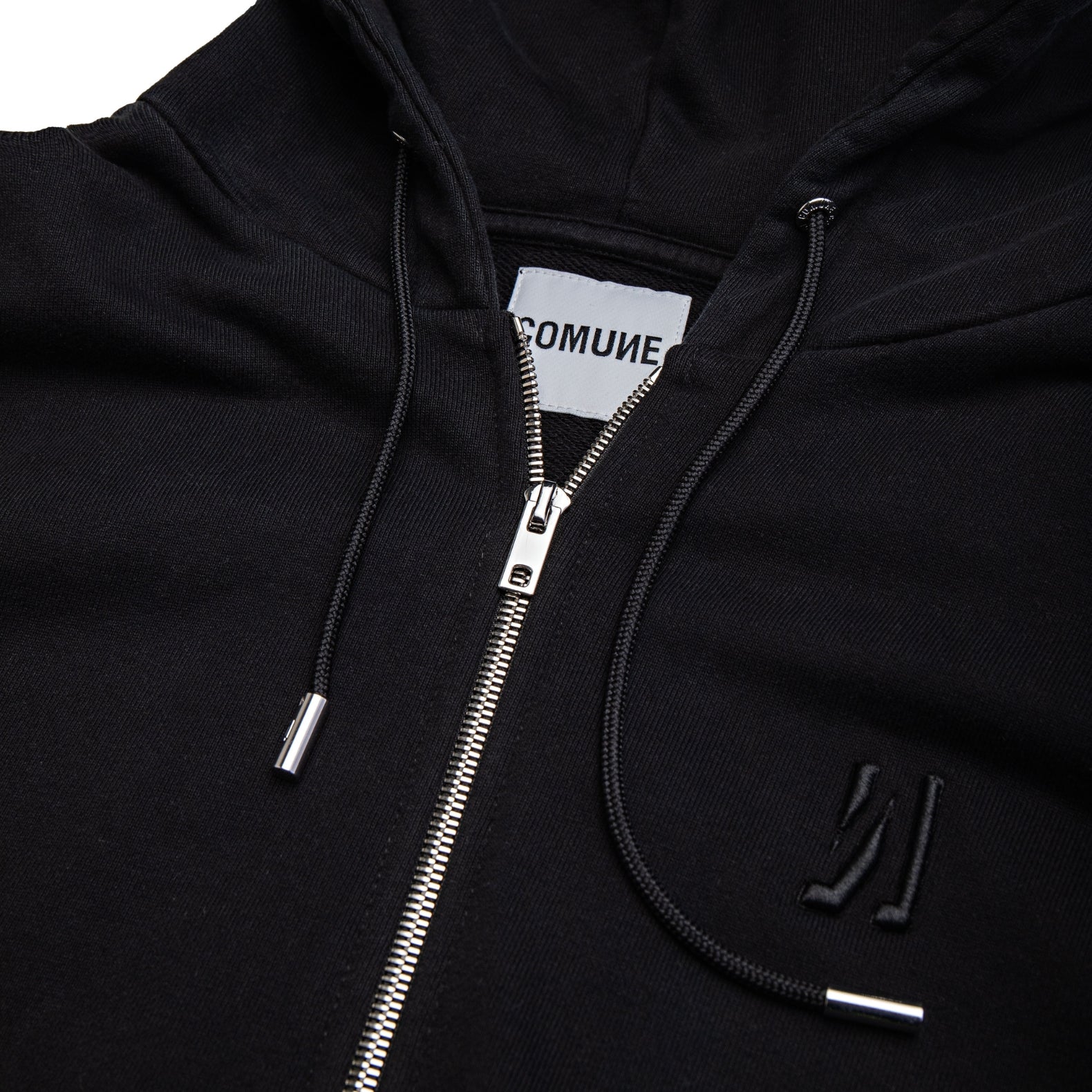Comune Luka Zip-up heavyweight cotton hoodie in black color on a white background, logo close up. COMUNE LUKA ZIP-UP | Black