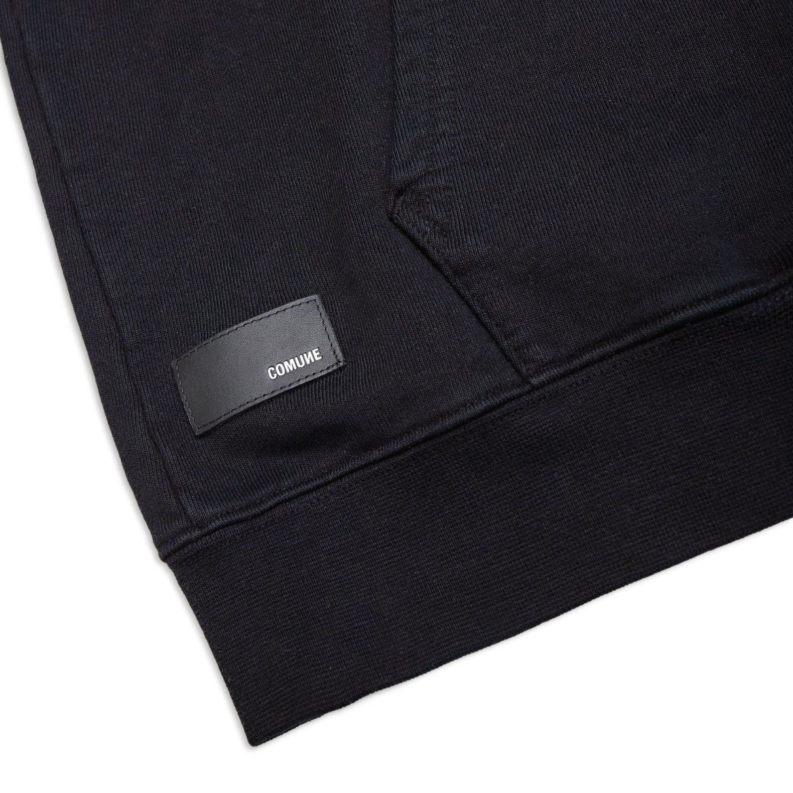 Comune Luka Zip-up heavyweight cotton hoodie in black color on a white background, leather patch close up. COMUNE LUKA ZIP-UP | Black