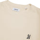 Comune Nori oversized tee in soft 100% supima cotton in bone color on white background, logo close up. COMUNE NORI OVERSIZED TEE | Bone