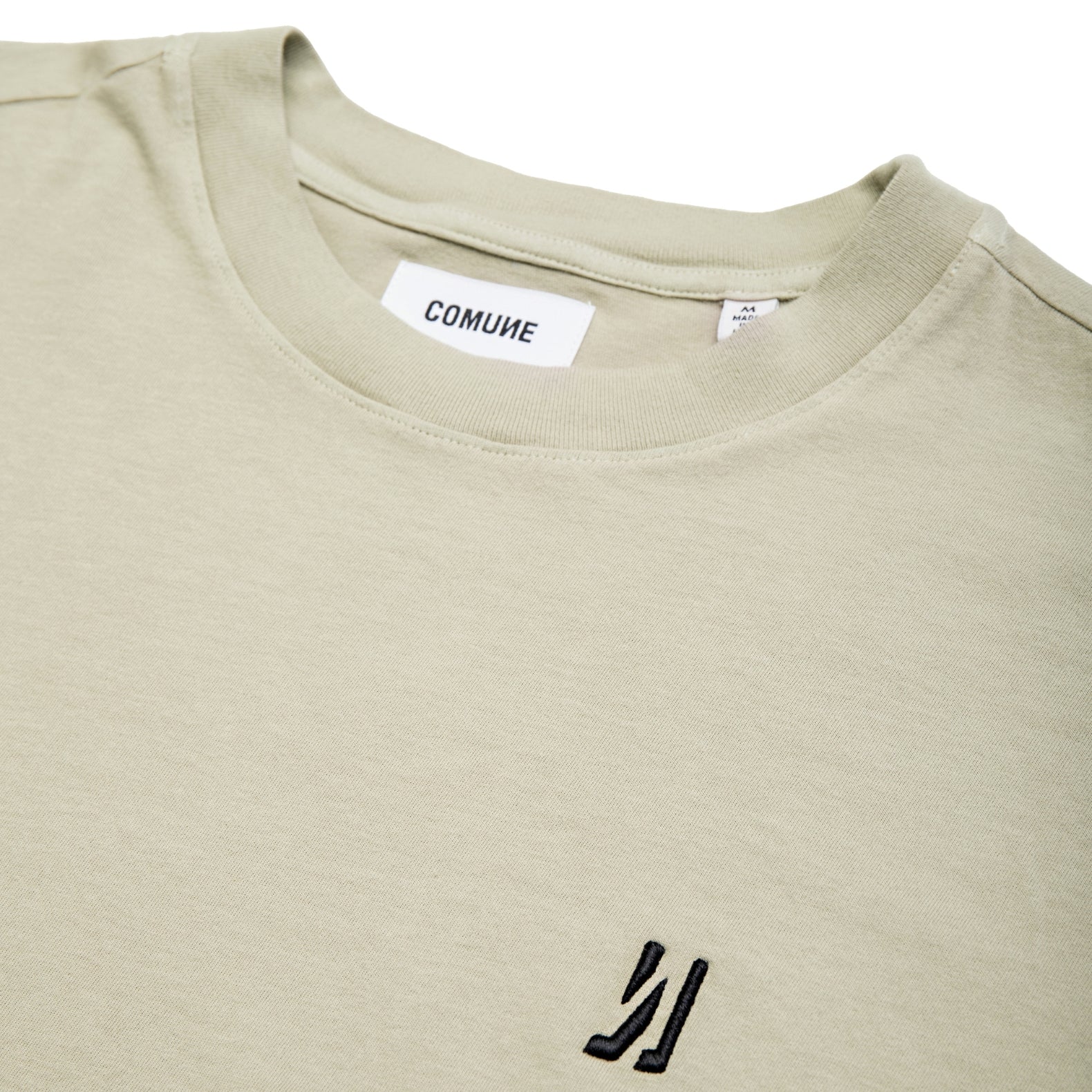 Comune Nori oversized tee in soft 100% supima cotton in sage color on white background, logo close up. COMUNE NORI OVERSIZED TEE | Sage