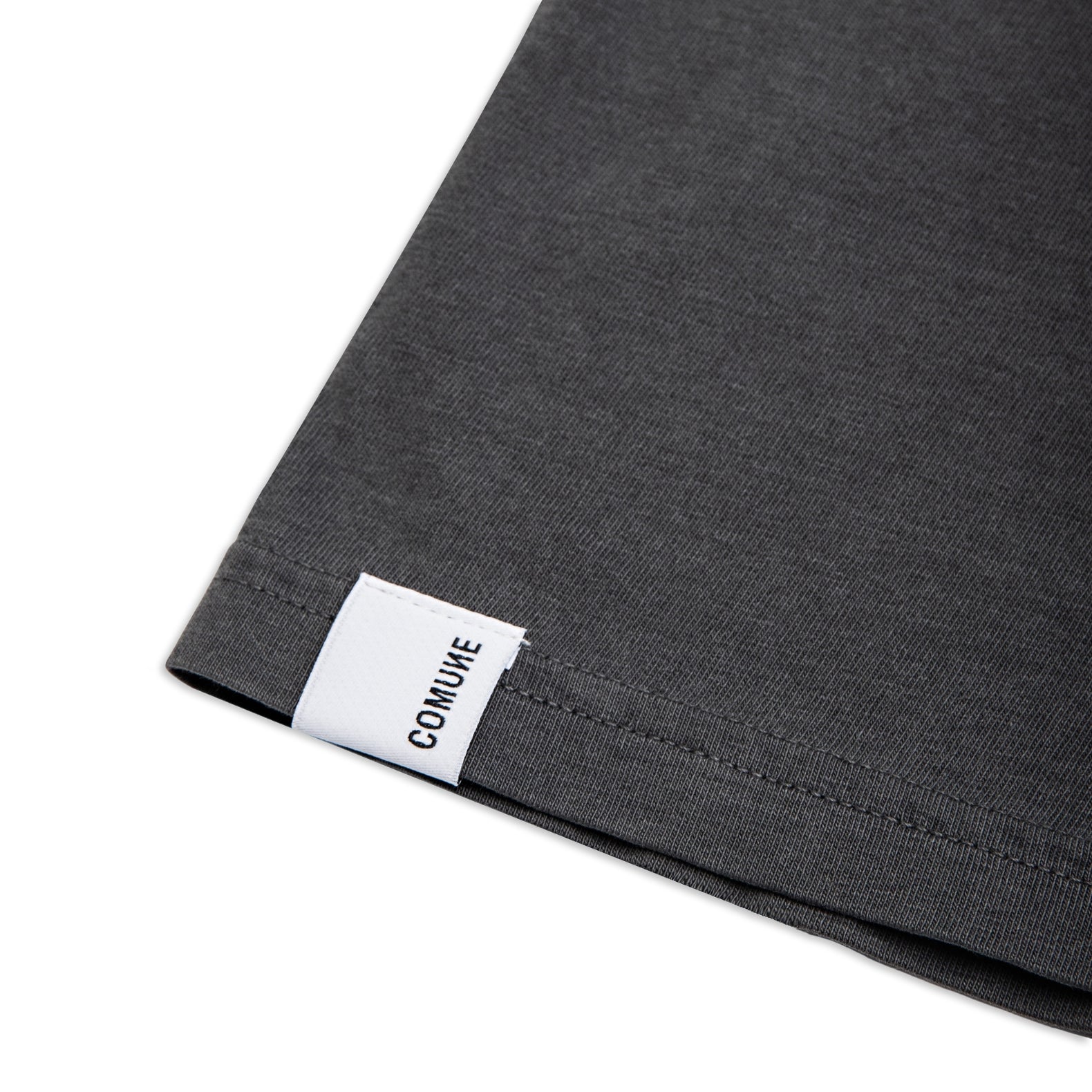 Comune Ryder oversized tee in soft 100% cotton in white color on white background, label and hem close up. COMUNE RYDER OVERSIZED TEE | Faded Black