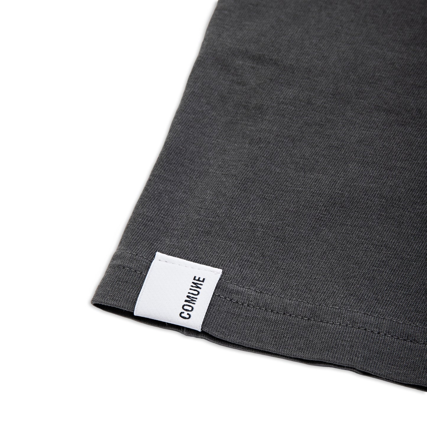 Comune Ryder tee in soft 100% cotton in faded black color on white background, label and hem close up. COMUNE RYDER TEE | Faded Black