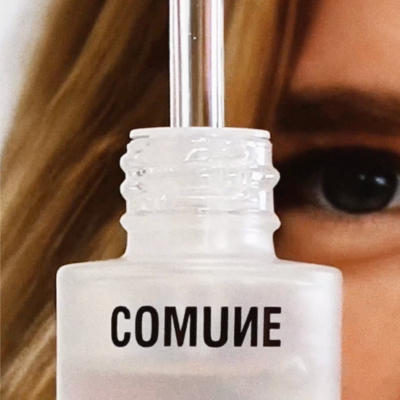 Comune Vita Boost Serum held by a women